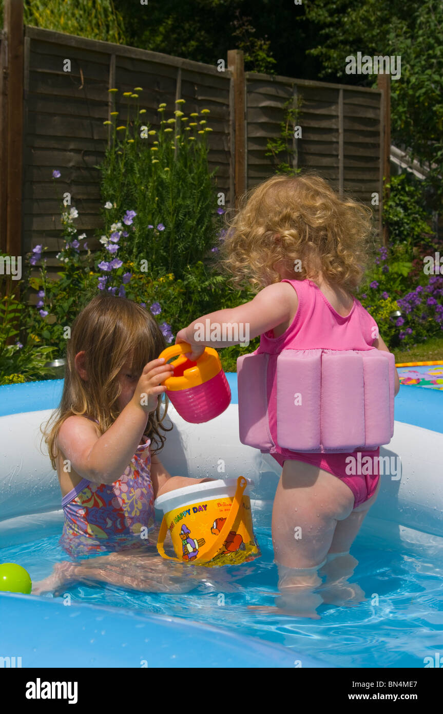 Two Young Female Children Playing In A Paddling pool Stock Photo Alamy