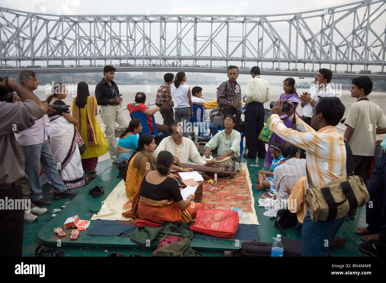 People enjoying music in boat in River Hooghly ; View of Howrah Bridge now Rabindra Setu; Calcutta Kolkata ; West Bengal ; India Stock Photo