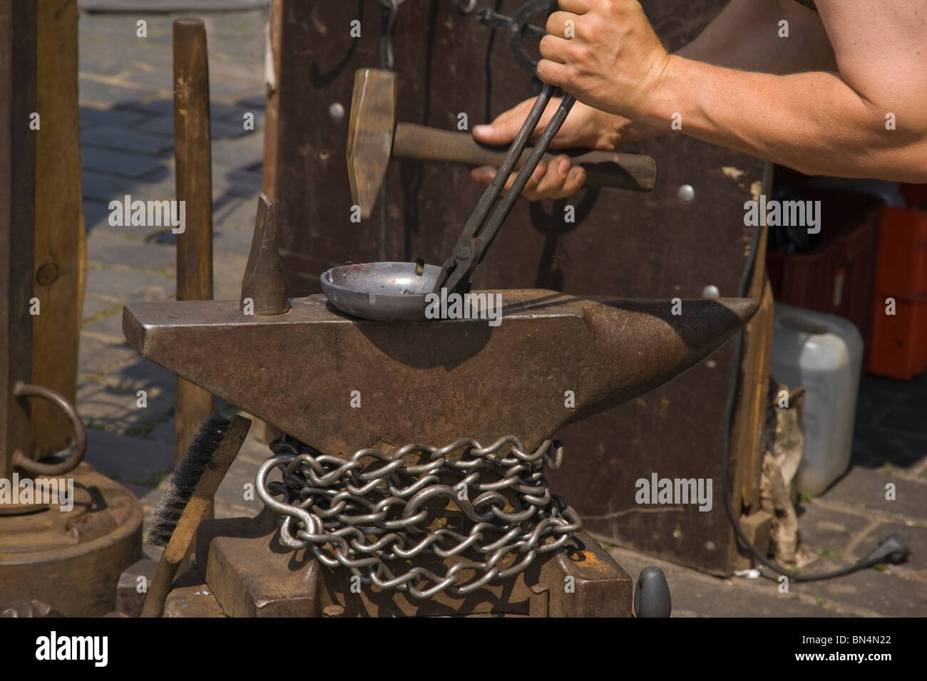 Blacksmith or metal worker hammering the metal Stock Photo