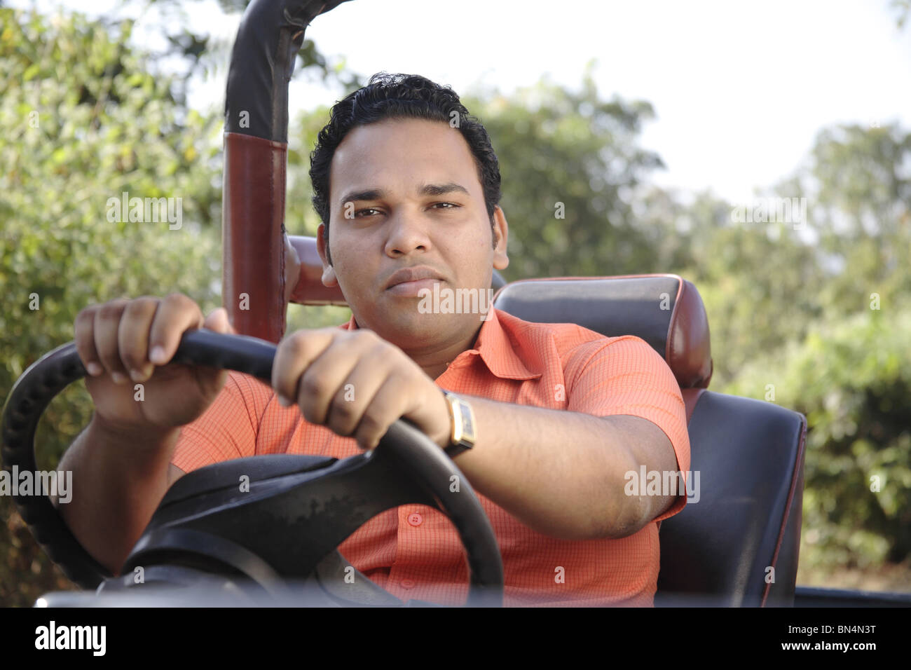 South Asian Indian young man sitting on driver's seat in India jeep and holding steering wheel ; India MR# 703H Stock Photo