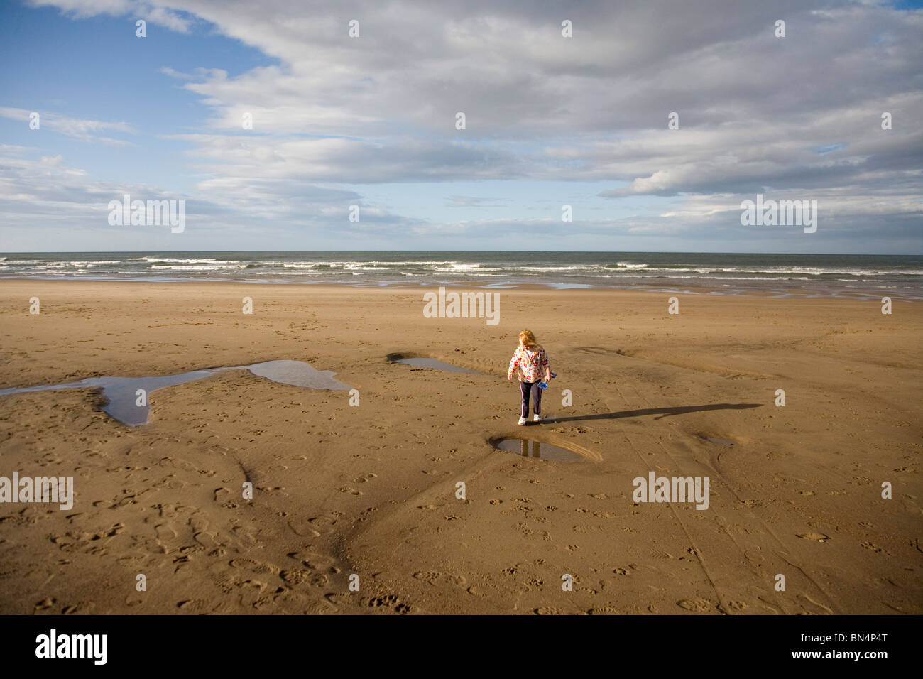Young girl alone on a beach Stock Photo