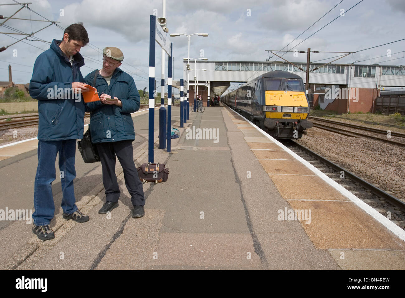 Trainspotters comparing notes on a platform at Peterborough Station. Stock Photo