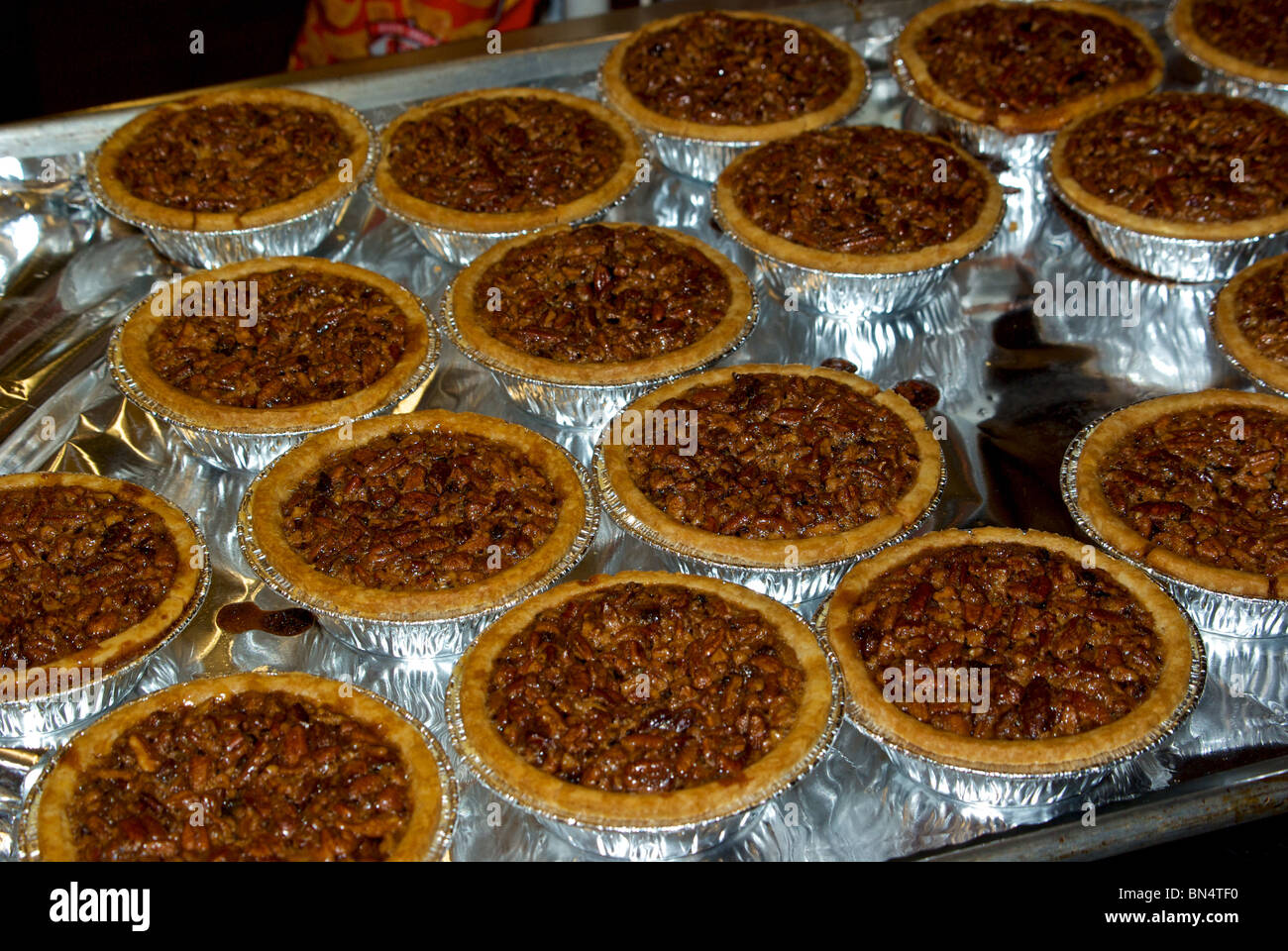 Aluminum foil lined tray of individual serving pecan pies at The