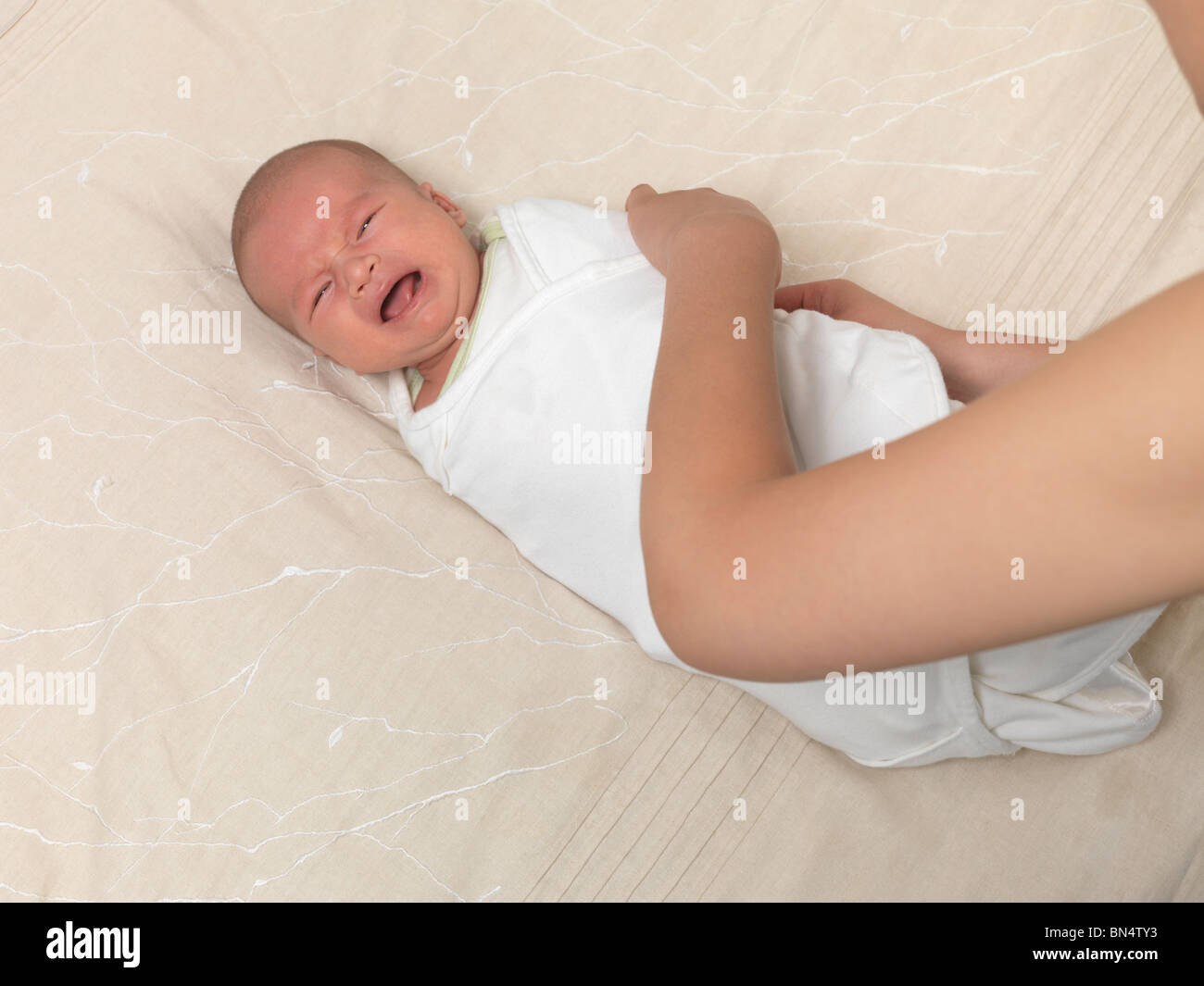 Mother swaddling a crying six week old baby boy stock photo alamy