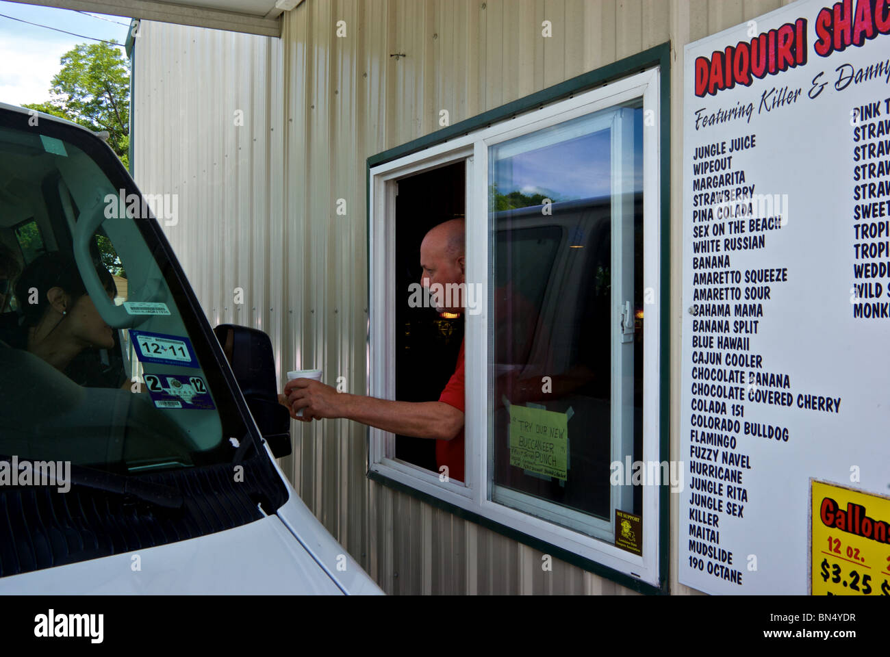 Picking up styrofoam cup of frozen flavored alcoholic drinks from drive