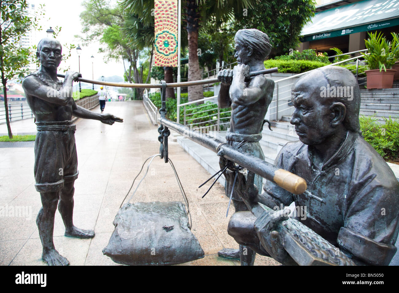 A bronze statue that depicts Chinese, Indian, and Malay laborers working together to build Singapore Stock Photo