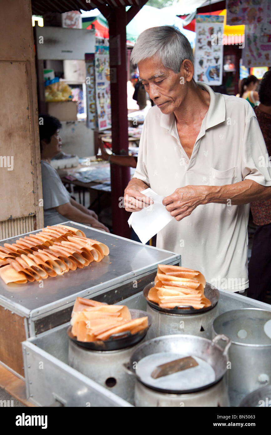 kueh kapet - coconut crisps served by a street hawker in the Kuala Lampur Chinese Market Stock Photo