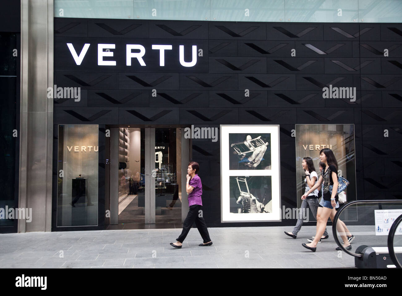 Singaporeans walk past the uber exclusive Vertu luxury cellphone store on Orchard Road Stock Photo