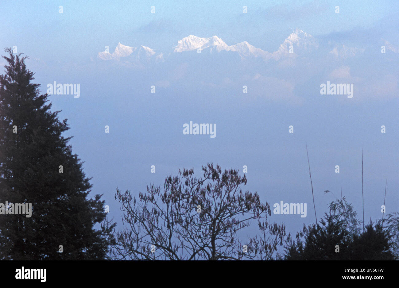 'Daybreak' - Kanchenjunga in the Himalayan mountain range begins to emerge through the early morning mist. Stock Photo