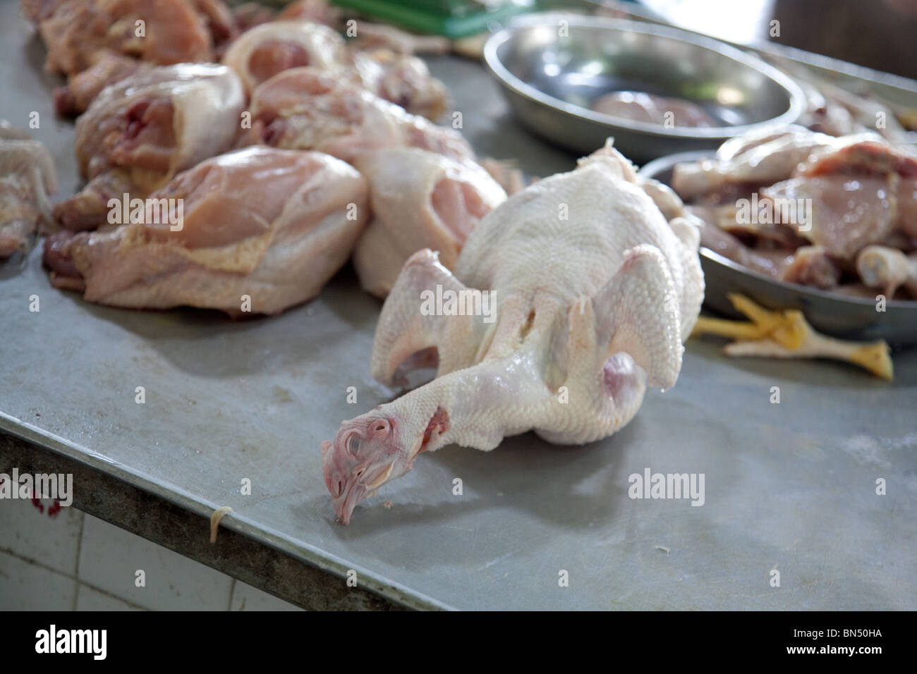 a whole chicken at the butcher shop in an open air market in Asia Stock Photo