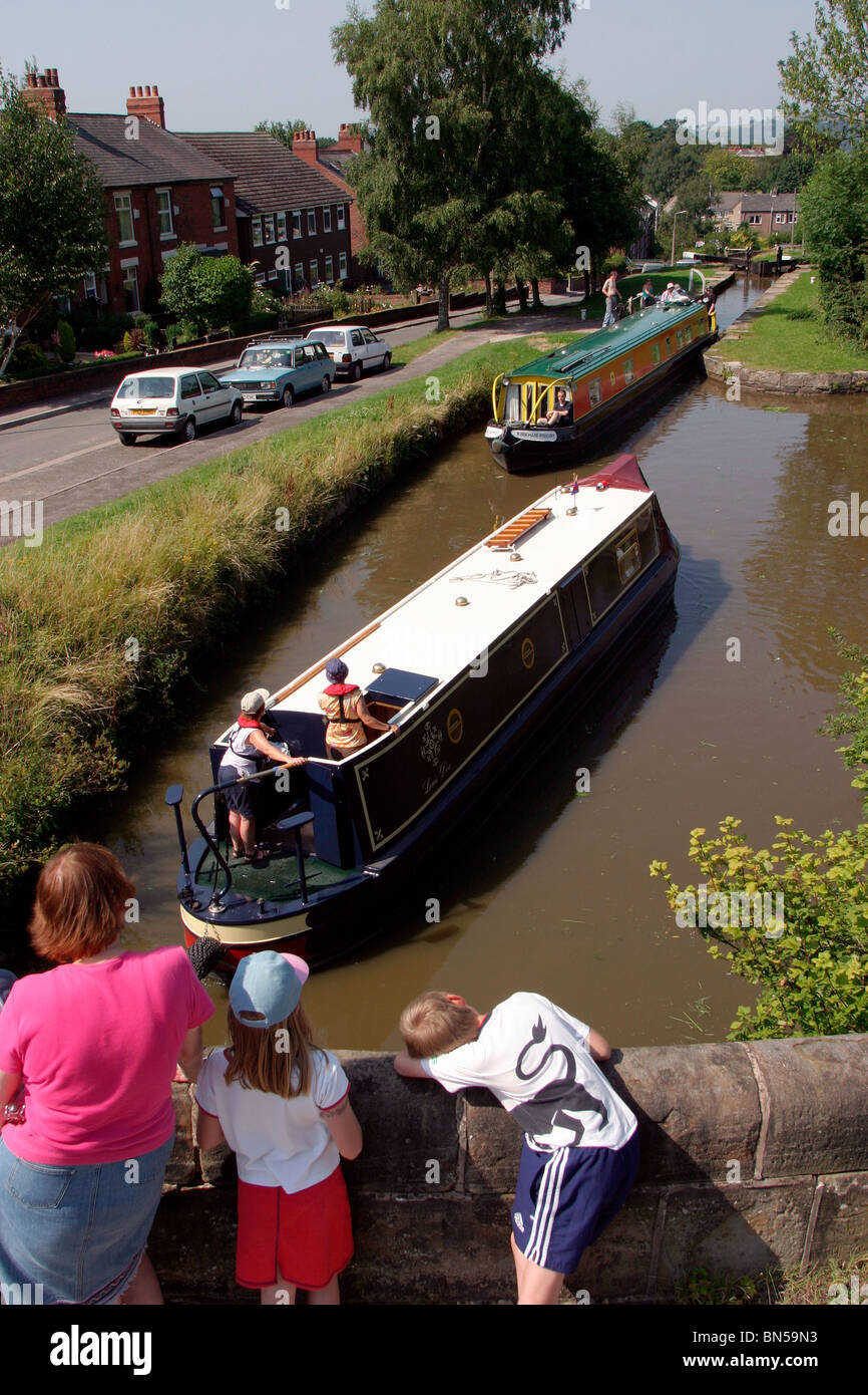 England, Cheshire, Stockport, Marple, mother and children watching narrow boats negotiate locks on Peak Forest Canal Stock Photo