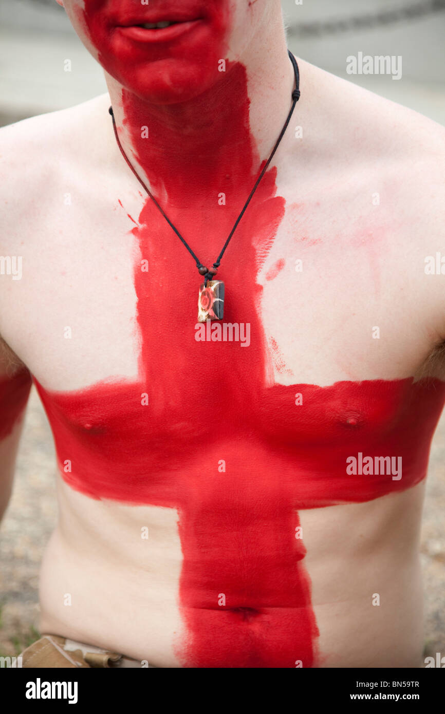 An England football fan paints himself with the St George's Cross flag. Stock Photo