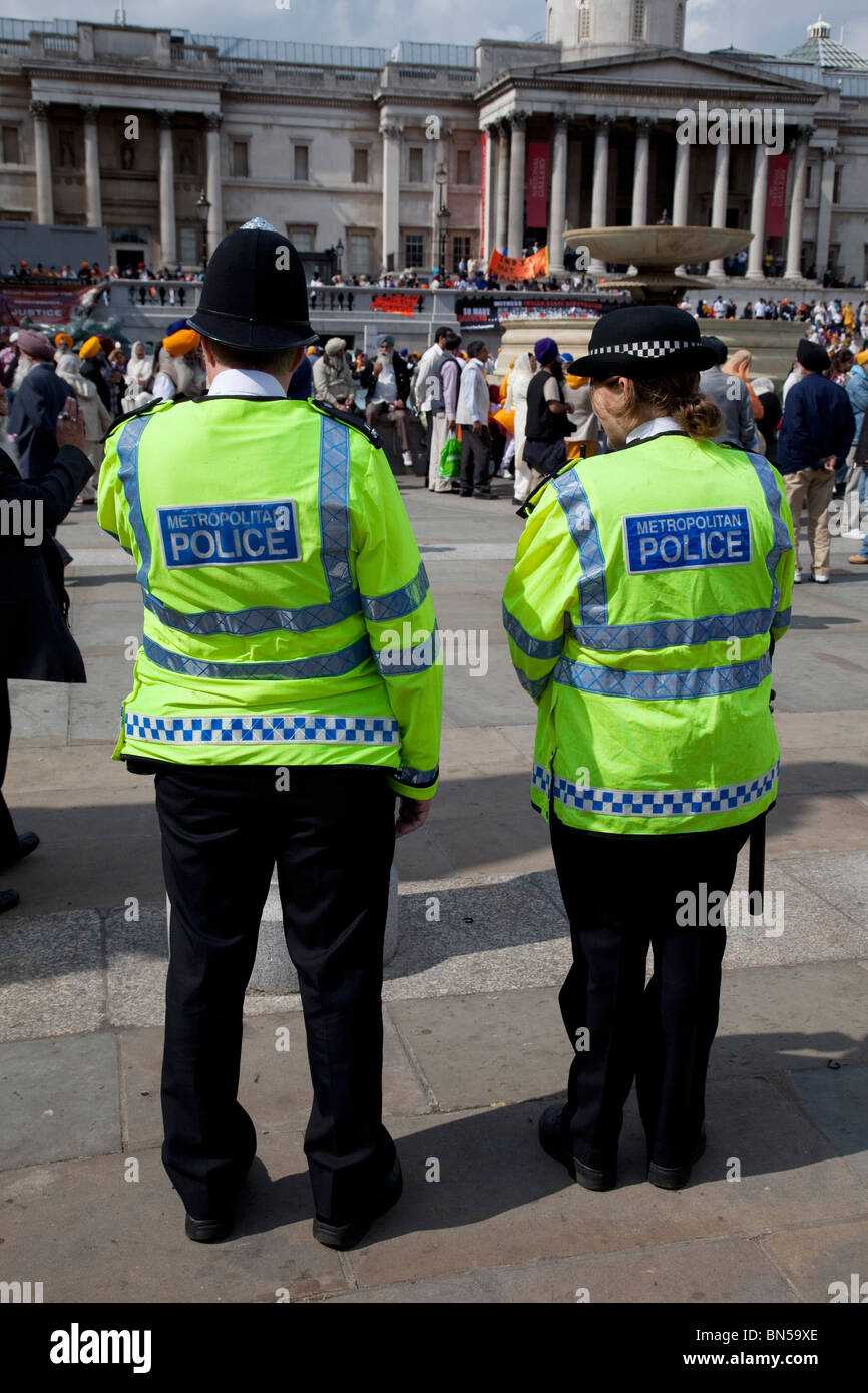 Two Police officers patrol in Trafalgar Square at a large event. The MPS, Metropolitan Police Service. Stock Photo