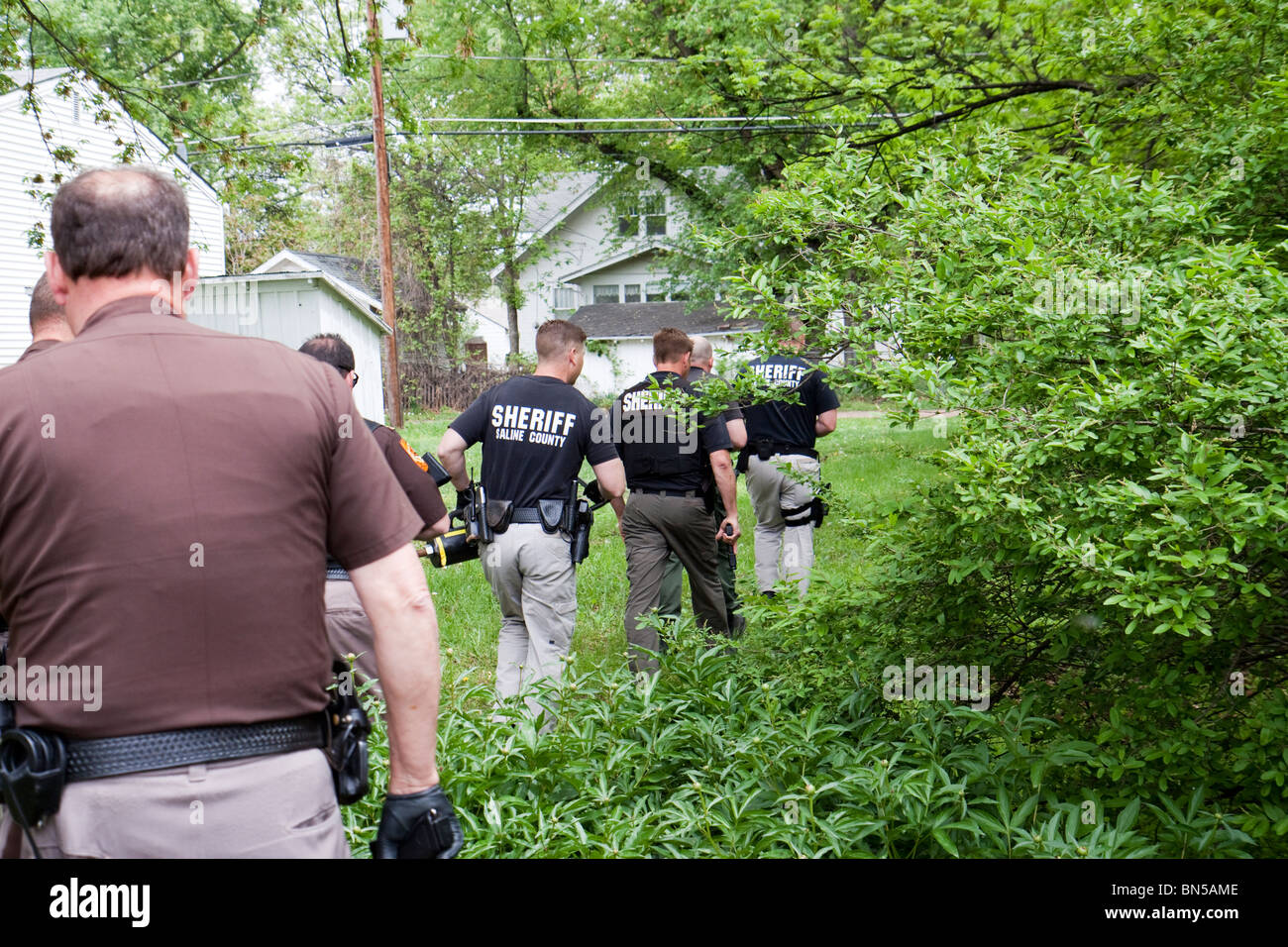 Deputy sheriff's serving drug related search warrant in a rural US community. Narcotics were located inside the residence. Stock Photo