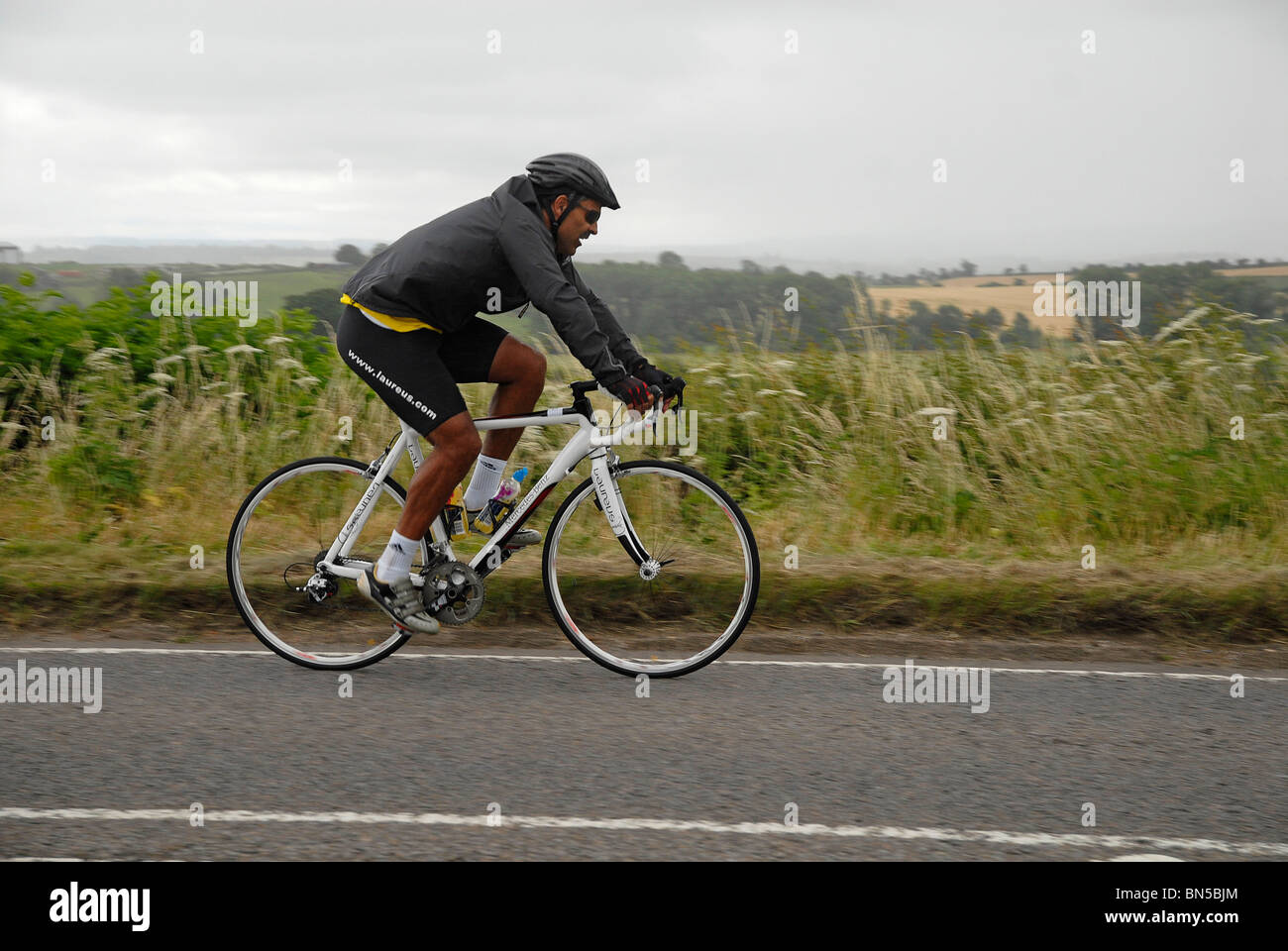 Daley Thompson at full stretch in Buckinghamshire, during a cycling event. Stock Photo