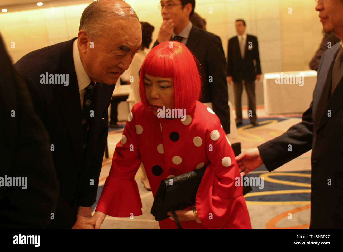 Japanese artist Yayoi Kusama (in red) and former Prime MInister Yasuhiro Nakasone ( on left of image) , Tokyo, Japan. Stock Photo