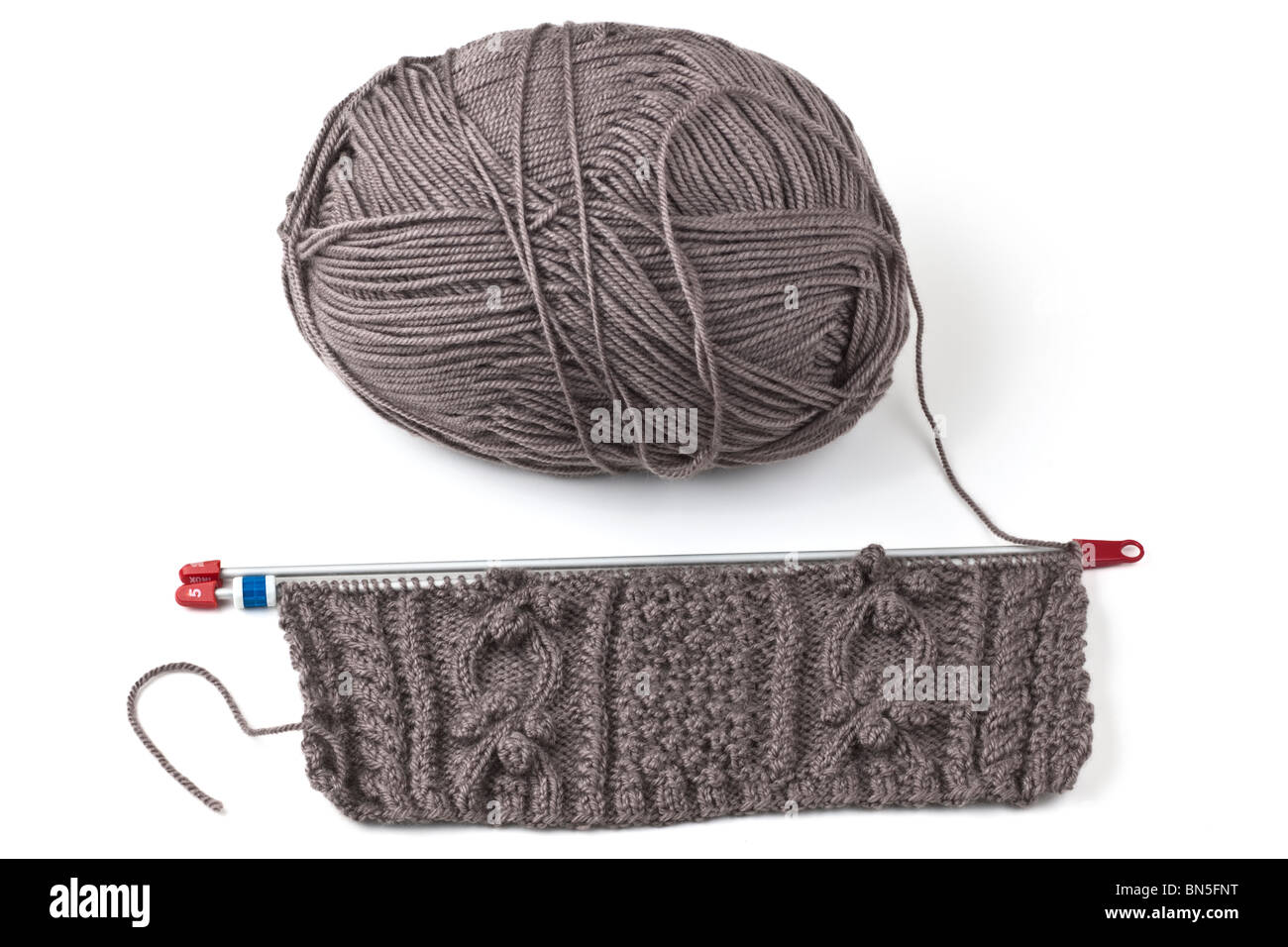 ball of brown wool and aran pattern knitting Stock Photo