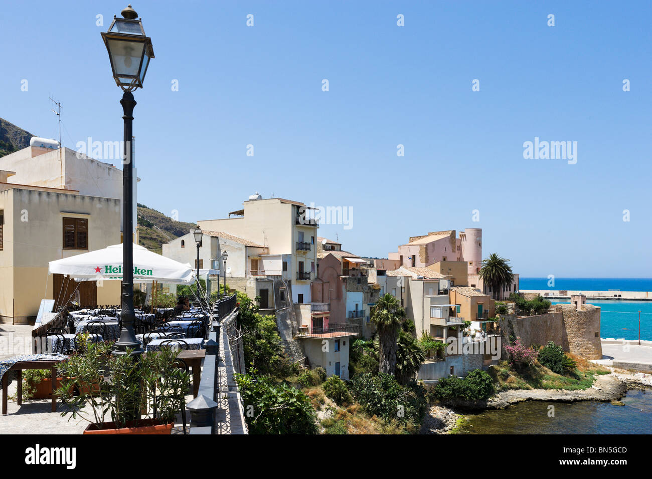 Restaurant on the seafront in Castellammare del Golfo with the castle in the background, North West Coast, Sicily, Italy Stock Photo