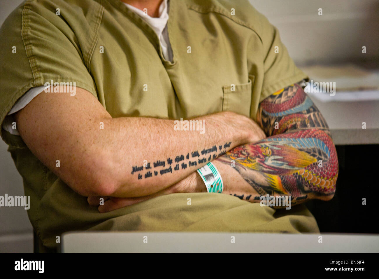 Tattoos contrast with prison clothing and prisoner identification wristband at the Santa Ana, CA, city jail. MODEL RELEASE Stock Photo