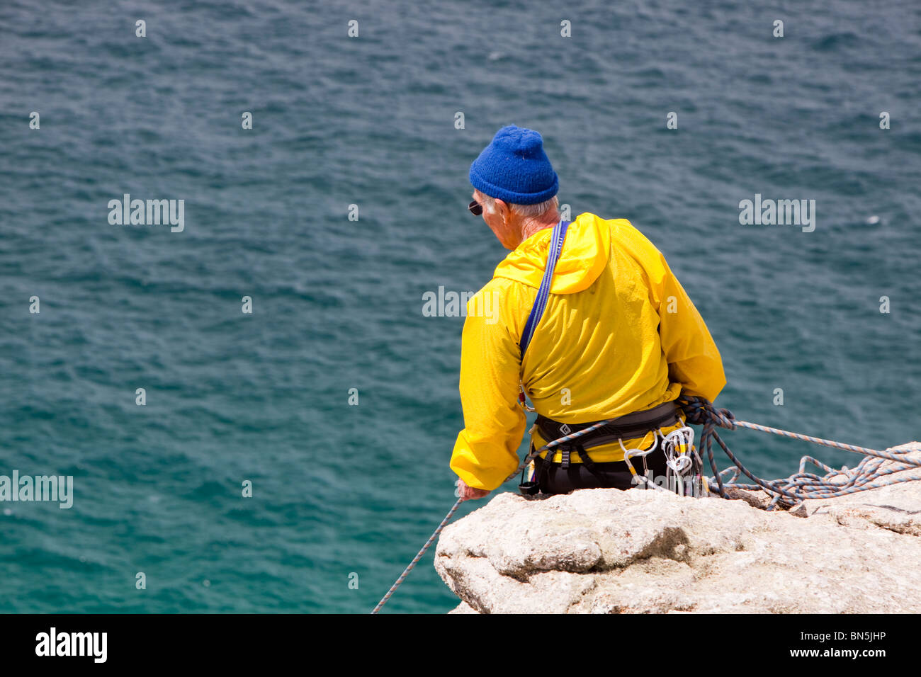 A couple in their 70's rock climbing on a sea cliff at Bosigran on the