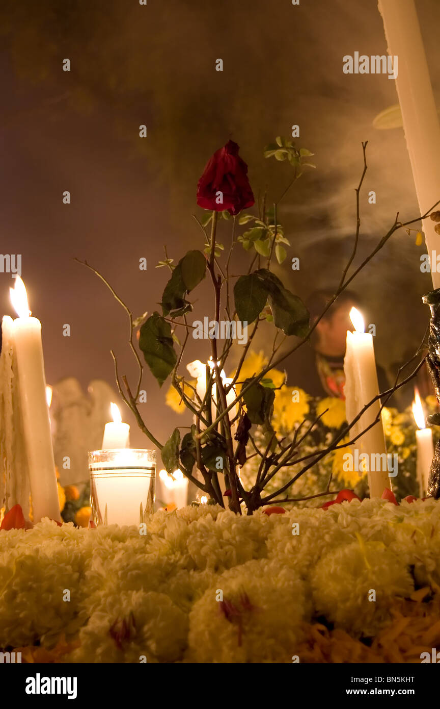 Flowers and candles over a tomb in Mixquic cemetery during la Alumbrada