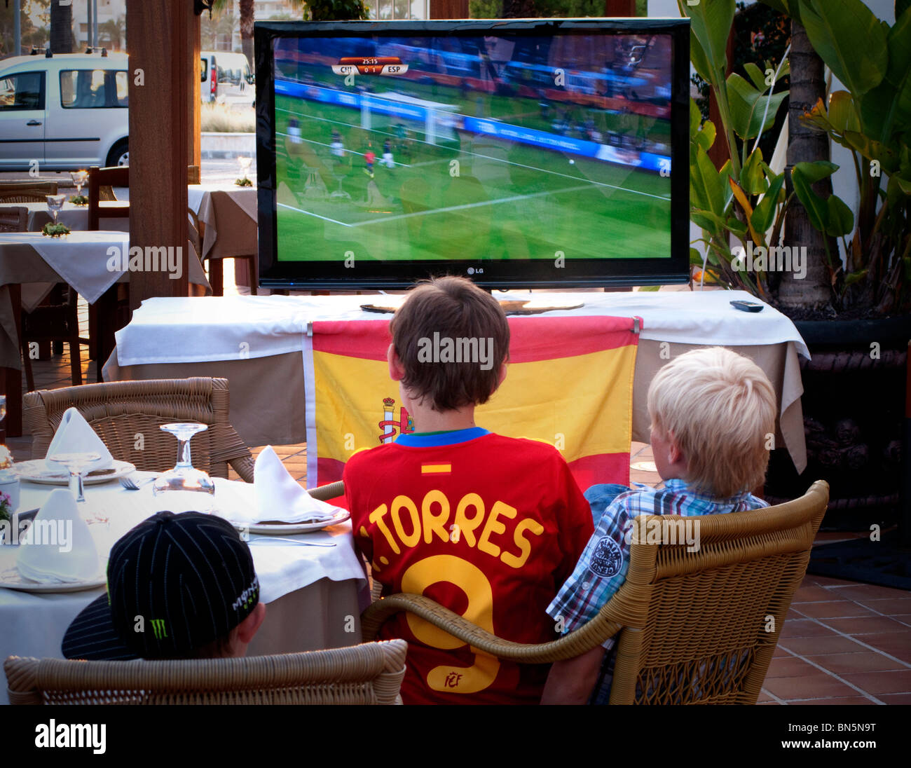 Children watch World Cup football on a television screen outside a Spanish  restaurant in Alcudia Majorca Stock Photo - Alamy