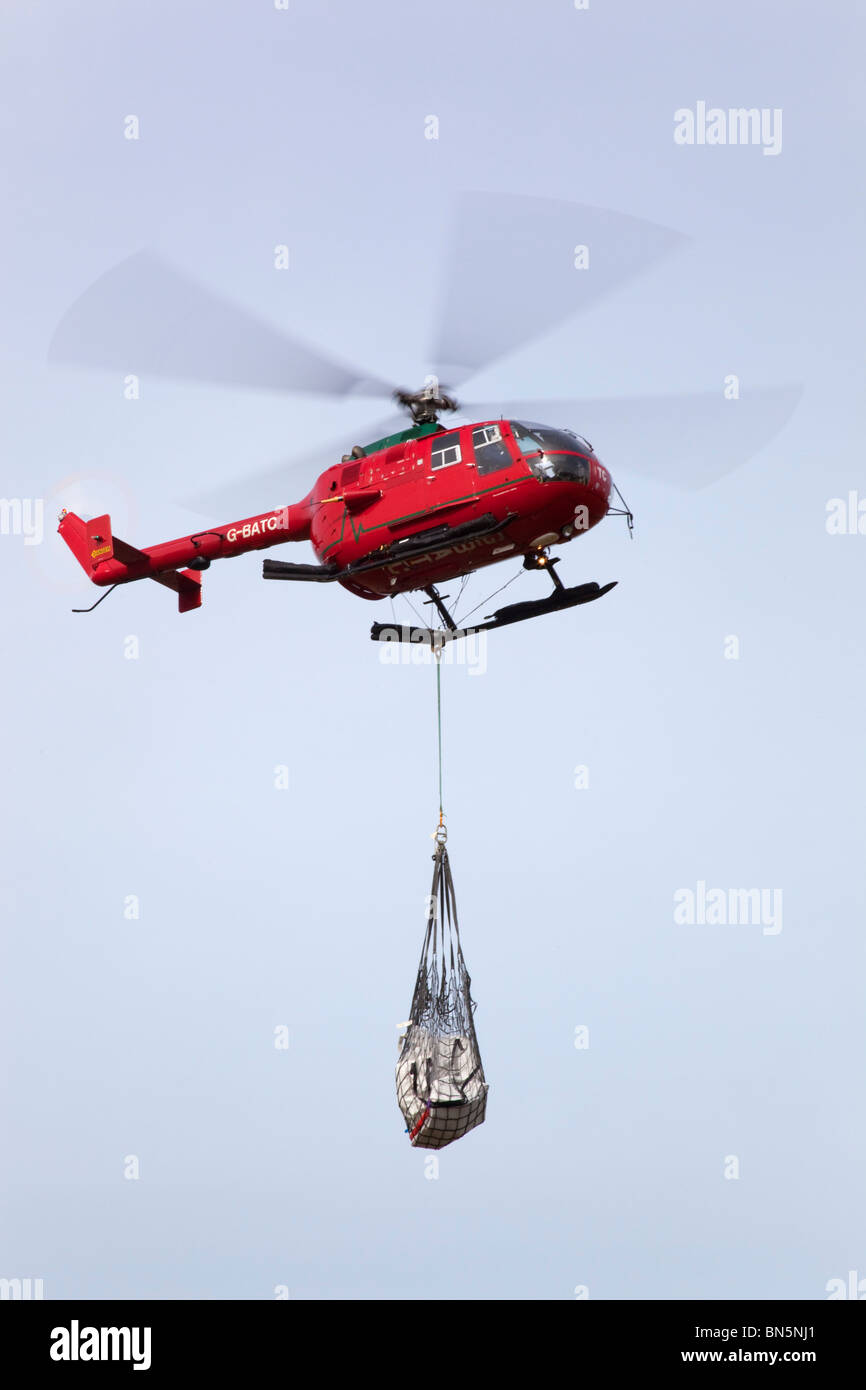 Helicopter carrying a load; Cornwall Stock Photo