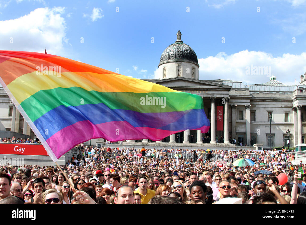 Rainbow flag and crowd in Trafalgar Square at the 40th Anniversary of Pride - Gay Pride Parade in London, 3rd July 2010 Stock Photo