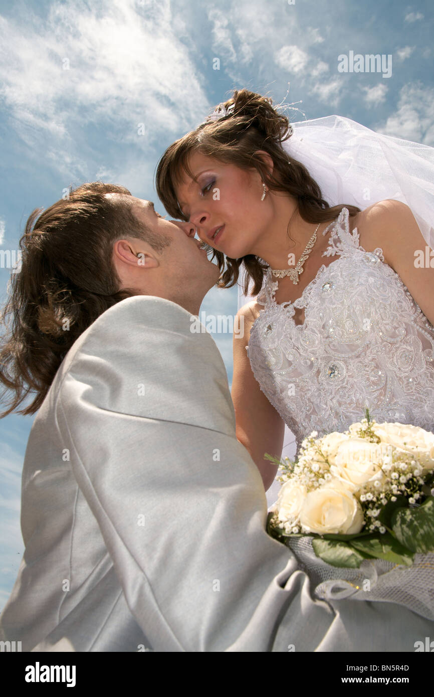 Groom and the bride embrace on a background of the dark blue sky Stock ...