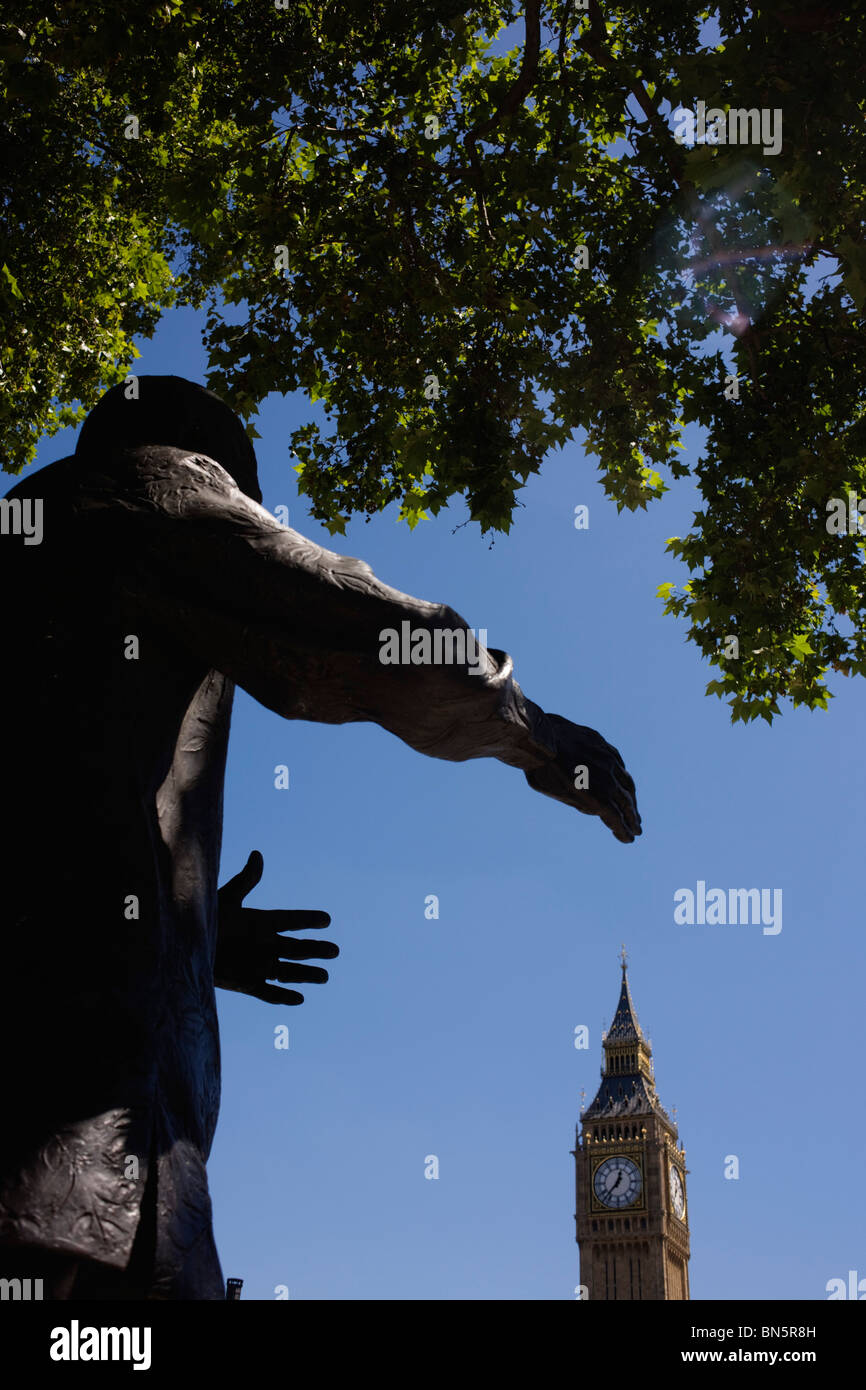 The reaching hands of ex-South African President Nelson Mandela's statue appear to grasp Elizabeth Tower. Stock Photo