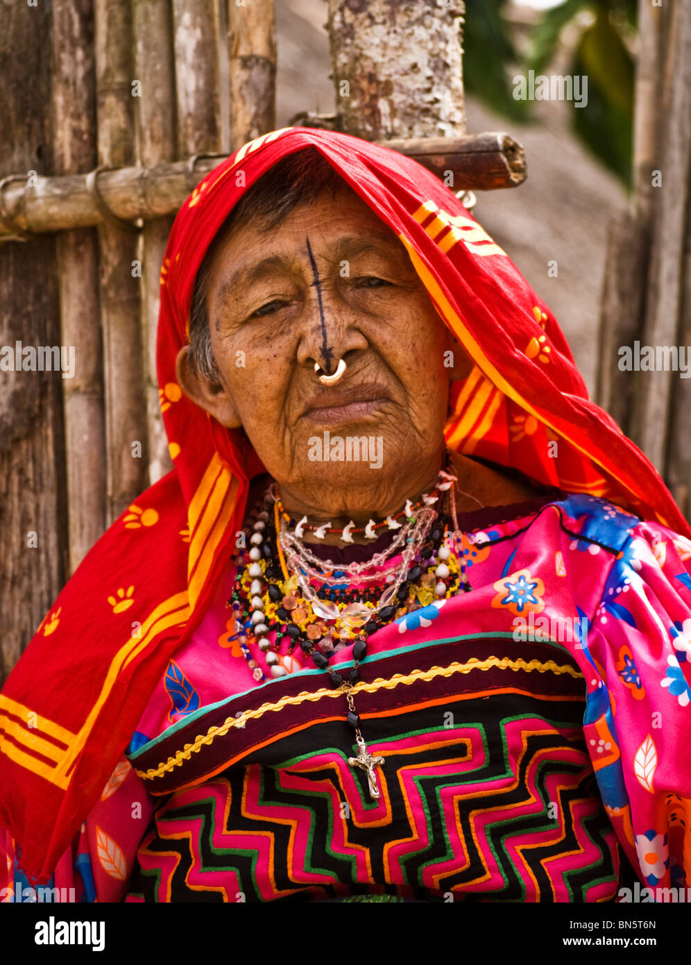 A head and shoulders close up of an older Kuna lady complete with traditional mola head covering, blouse, nose ring and tattoo Stock Photo