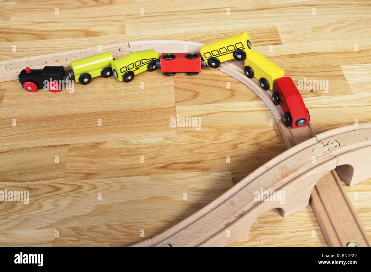 Traditional wooden train set left by child at home looking like an accident Stock Photo