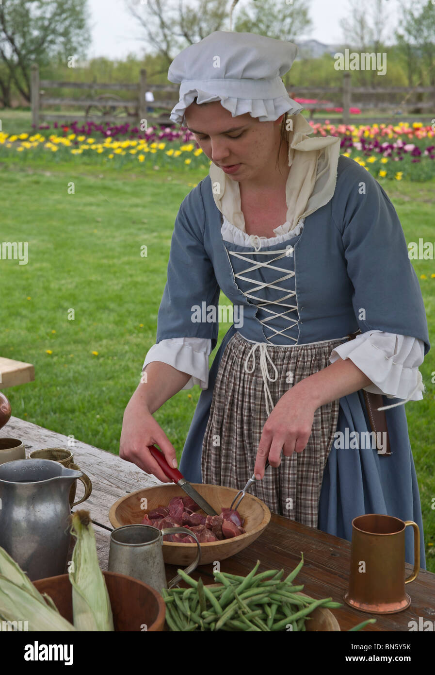 Tulip time festival Dutch Holland Michigan in USA  A Dutch woman dressed in traditional costume preparing a meal during a trade fair hi-res Stock Photo