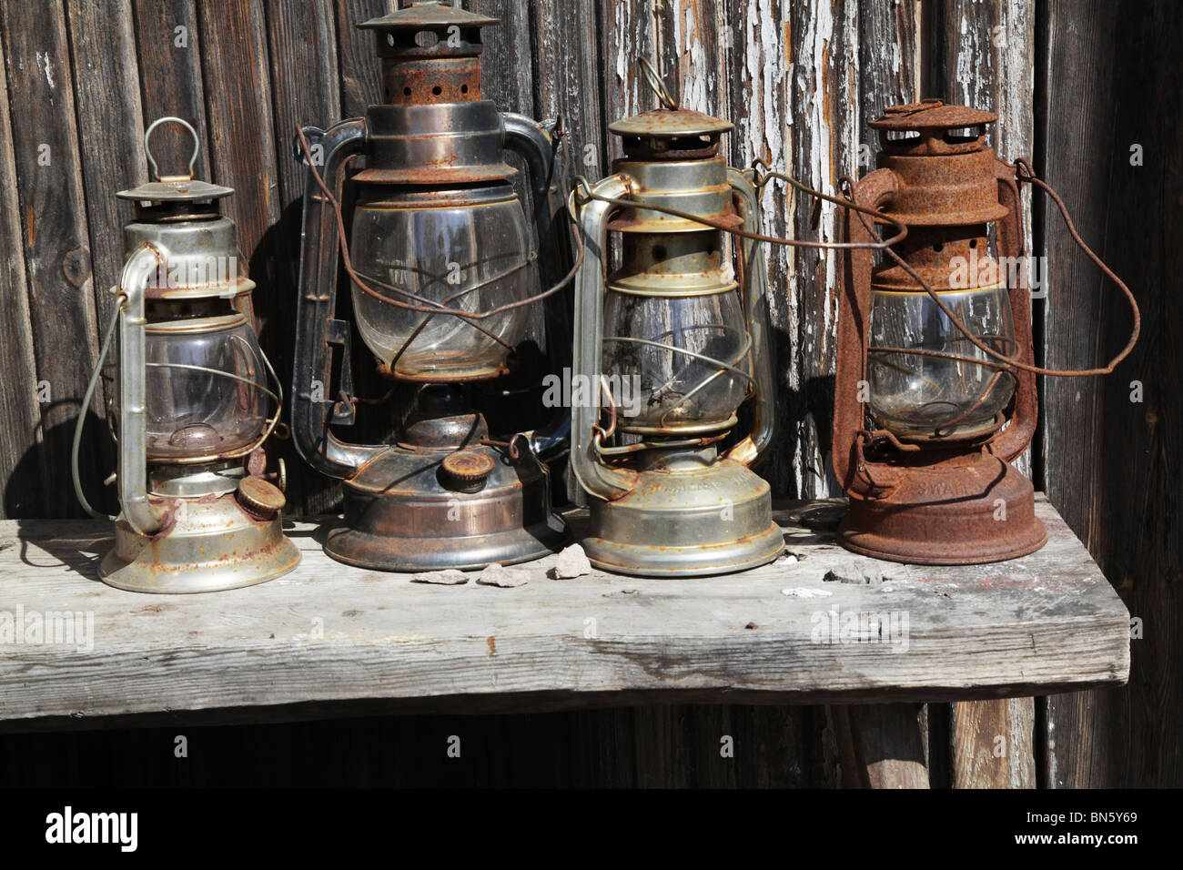 A line of antique gas lanterns sitting on a table in a farm Stock Photo -  Alamy
