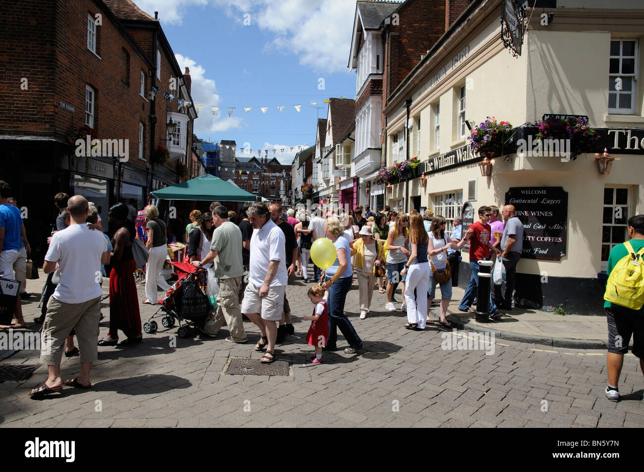 Winchester Hat Fair an annual event Winchester Hampshire UK crowded street with market stalls and a public house Stock Photo