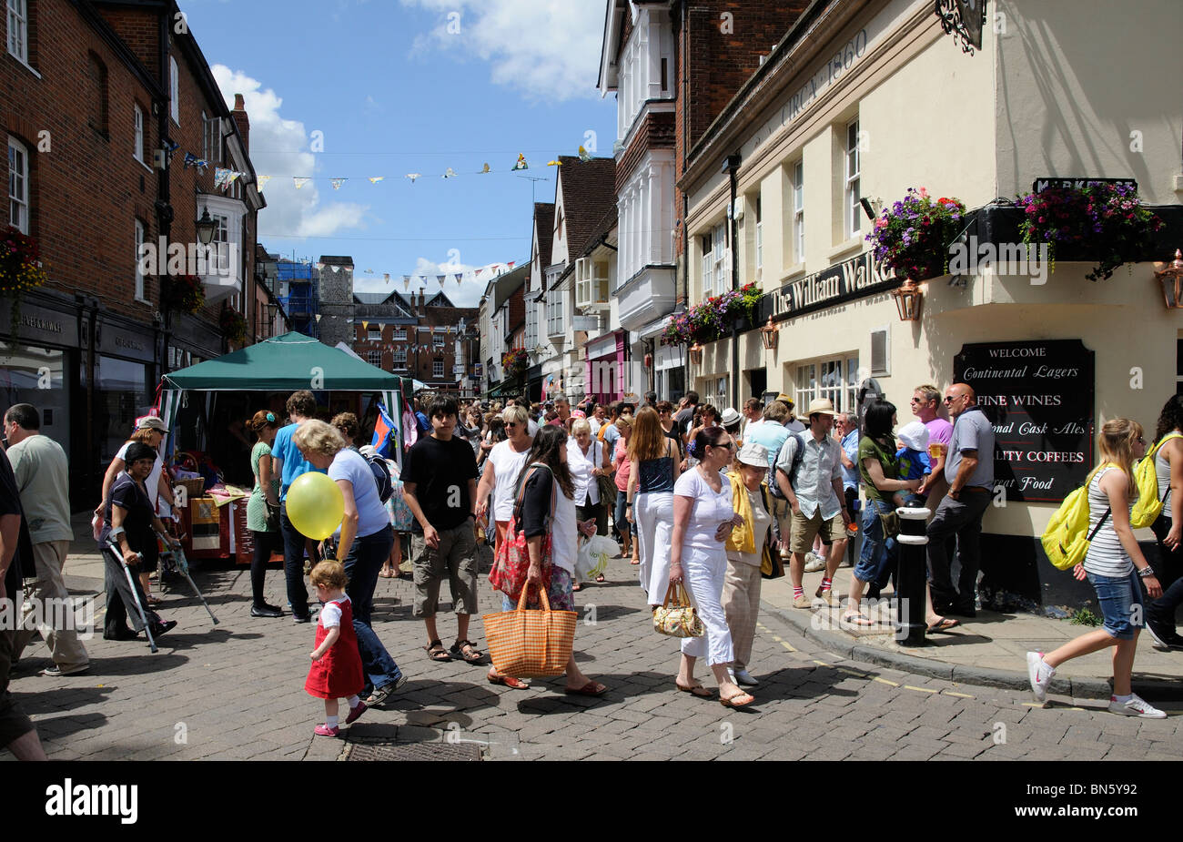 Winchester Hat Fair an annual event Winchester Hampshire UK crowded street with market stalls and a public house Stock Photo