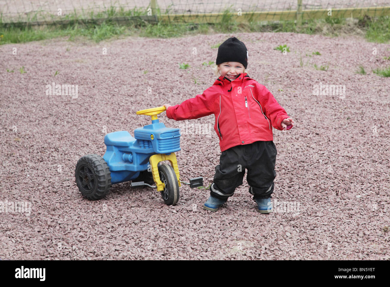 Toddler girl in nursery pretending to be a farmer with a tractor MODEL RELEASED Stock Photo