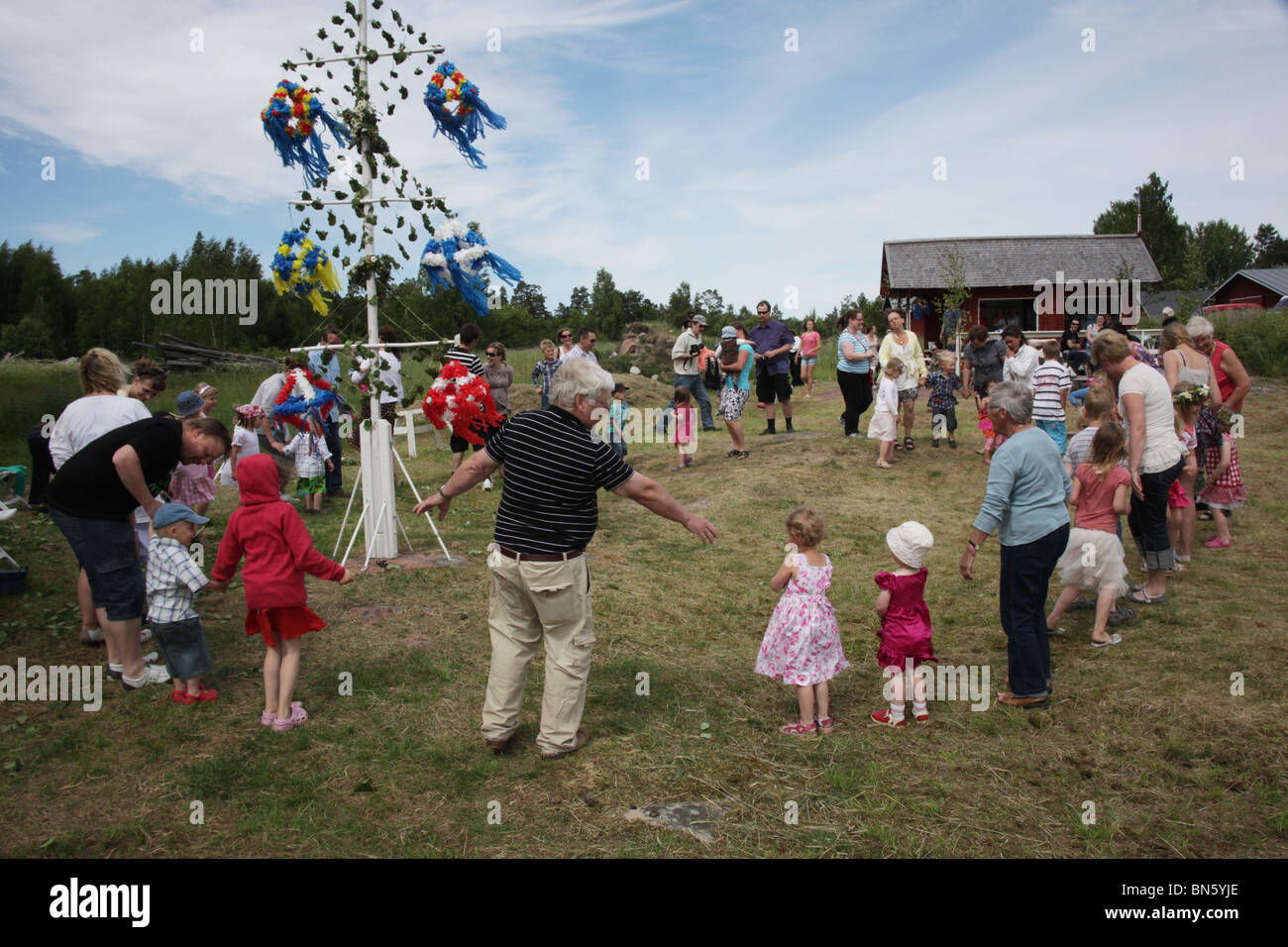 NORDIC TRADITIONAL MIDSUMMER FAMILY FAMILIES: Families dancing around the Midsummer pole on the Aland archipelago Finland Stock Photo