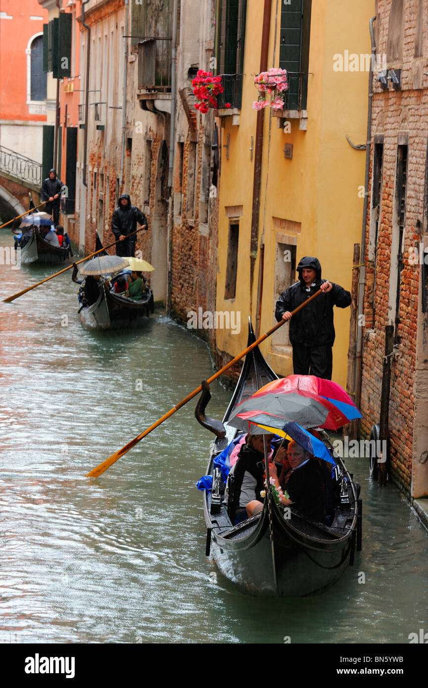Gondoliers navigating the narrow canals of Venice Stock Photo