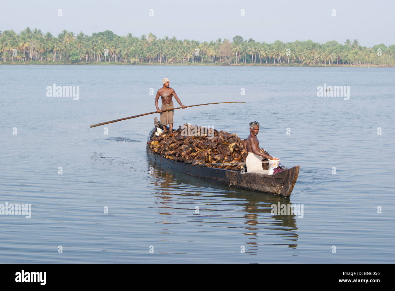 Small boat traveling in backwaters of kerala carrying huge 