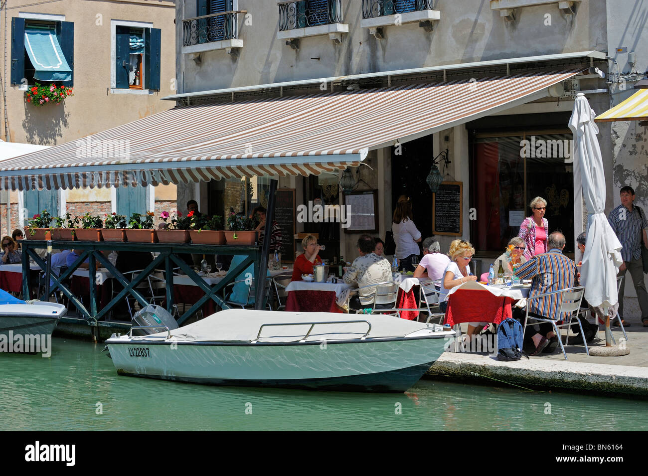 Diners in a canalside restaurant on the island of Murano Stock Photo