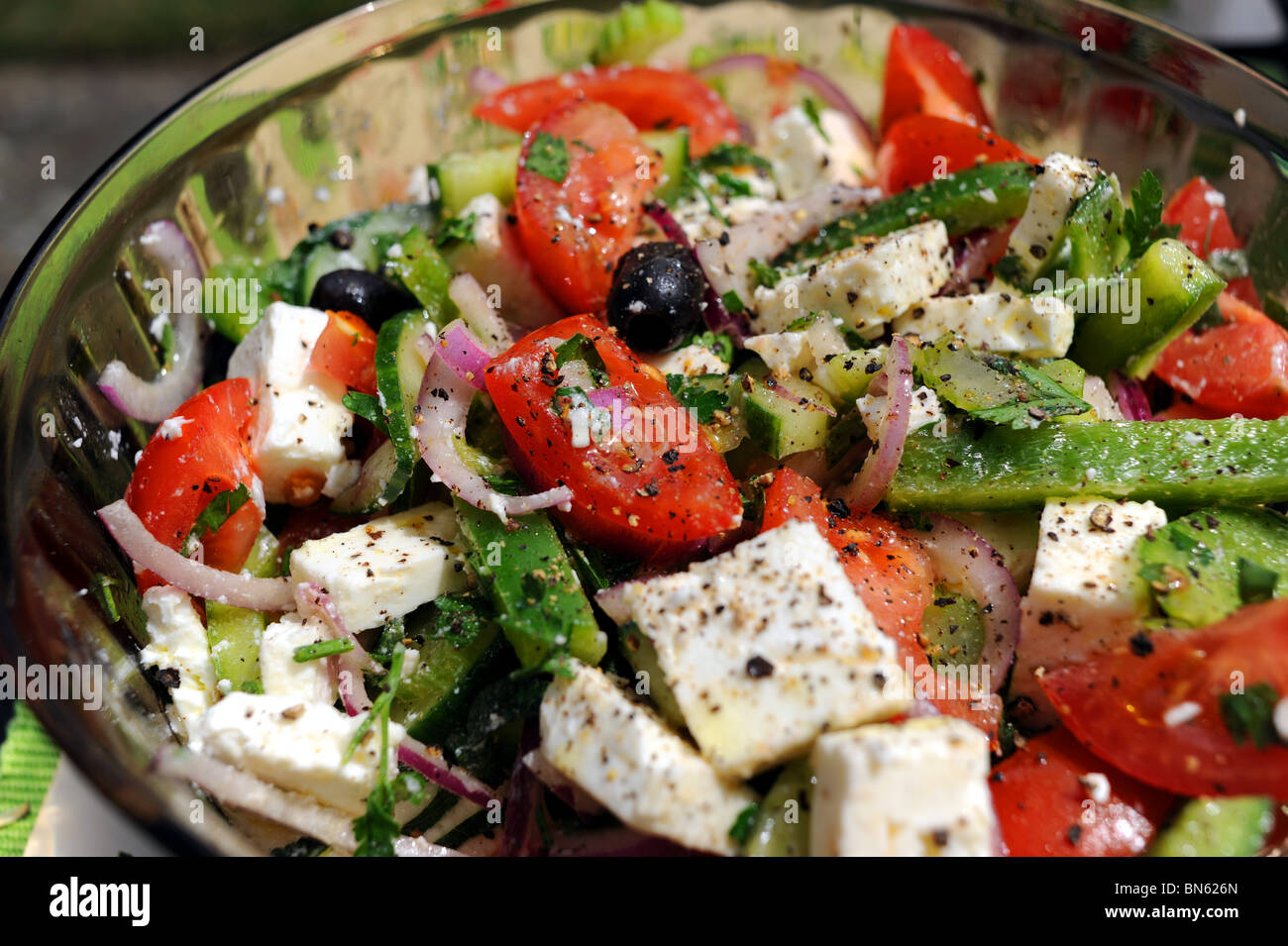 Fresh made Greek Salad with tomatoes green peppers red onion feta cheese and black olives Stock Photo