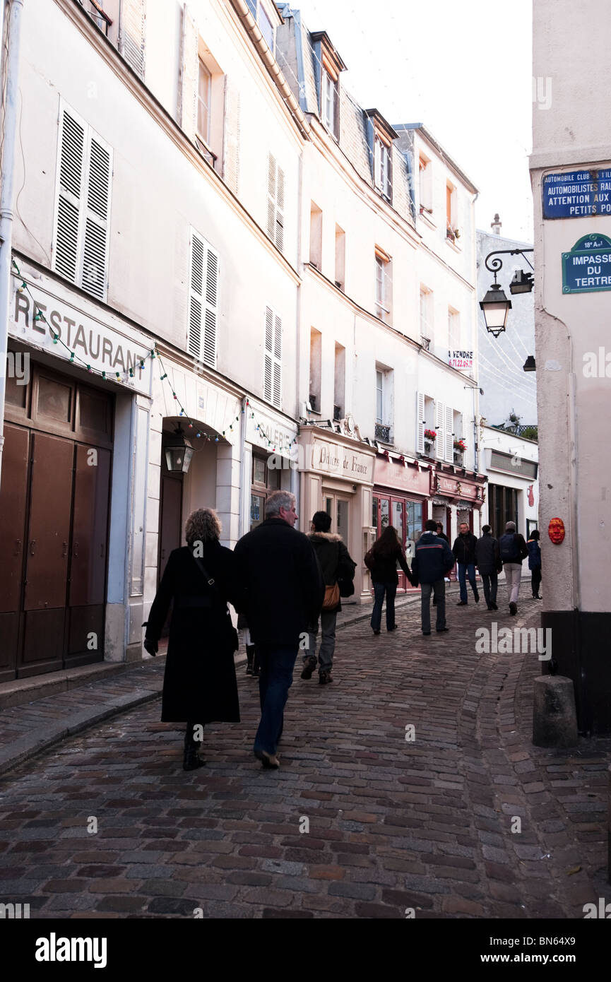 Groups of people walk the streets of Montmartre in Paris in the early morning. Stock Photo