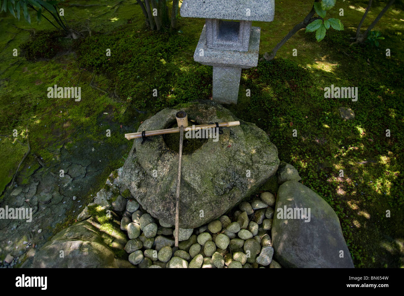 A stone lantern and water basin with bamboo dipper by the tea house at Kenninji Temple, Kyoto Stock Photo