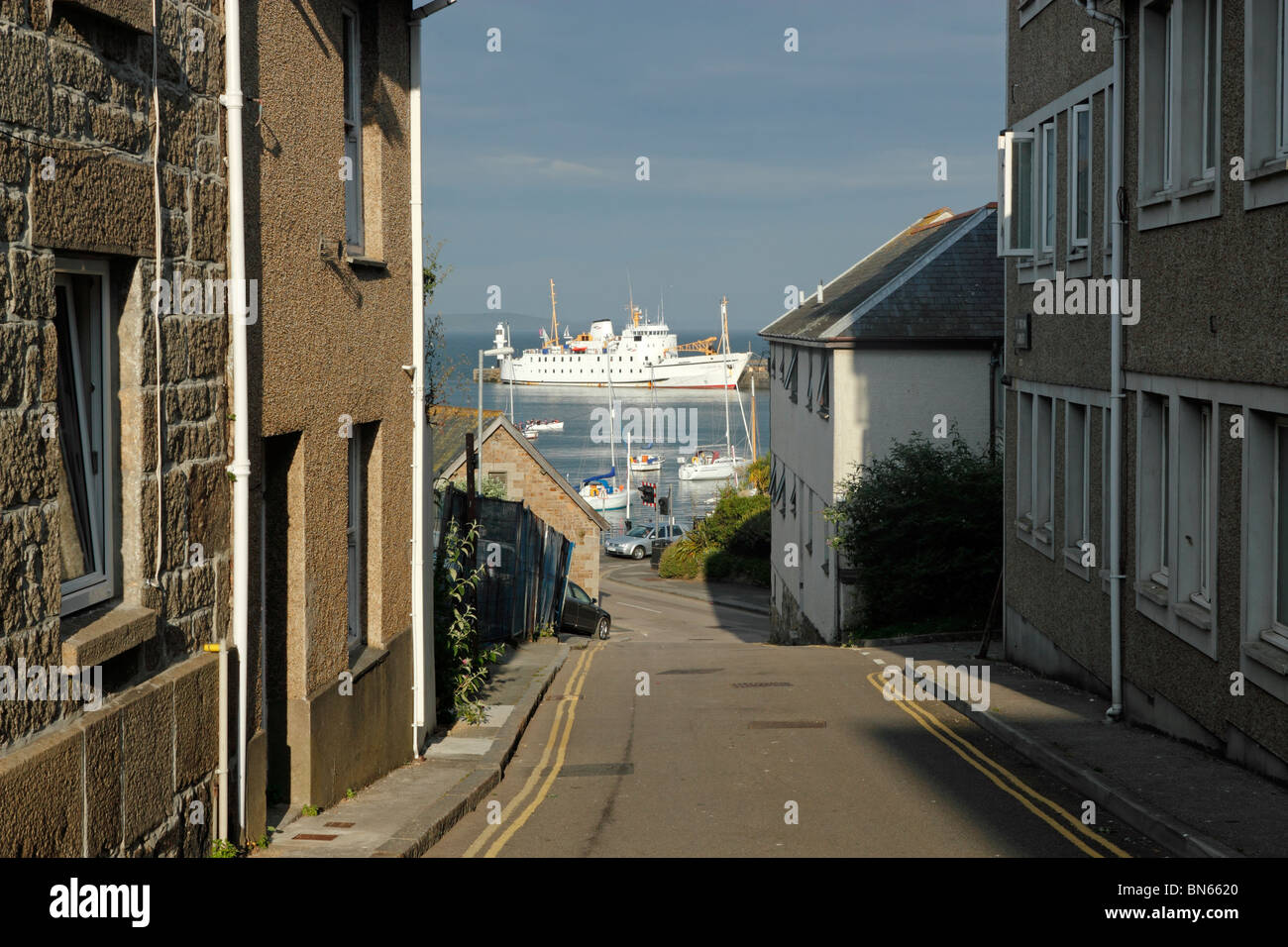 Looking down a street in Penzance with the Scillonian III in the harbour. Stock Photo
