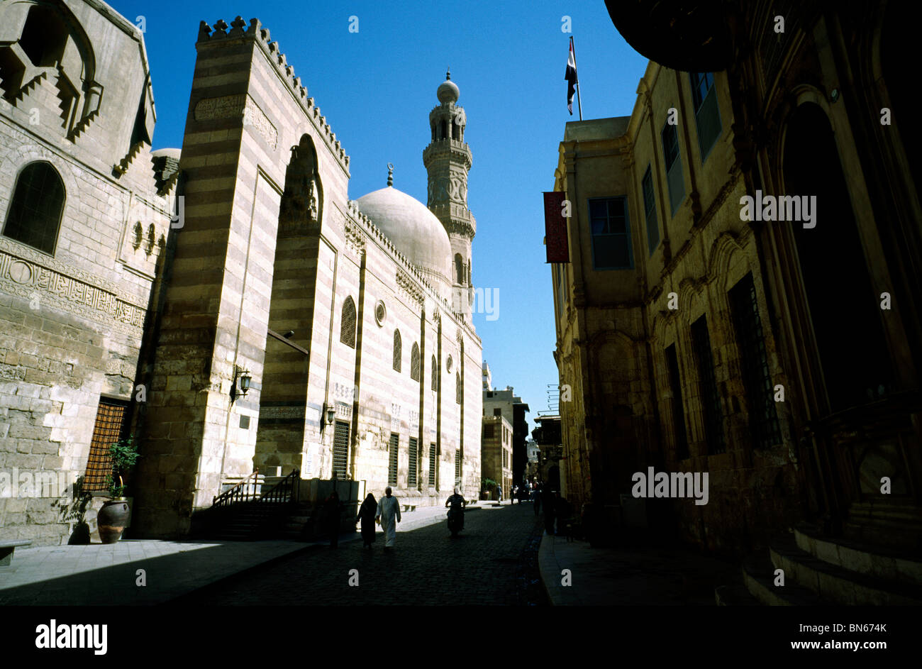 View of Sharia al-Muizz in Islamic Cairo with the Madrasah Khanqah of Sultan Barquq on the left next to the Qalaoun Complex. Stock Photo