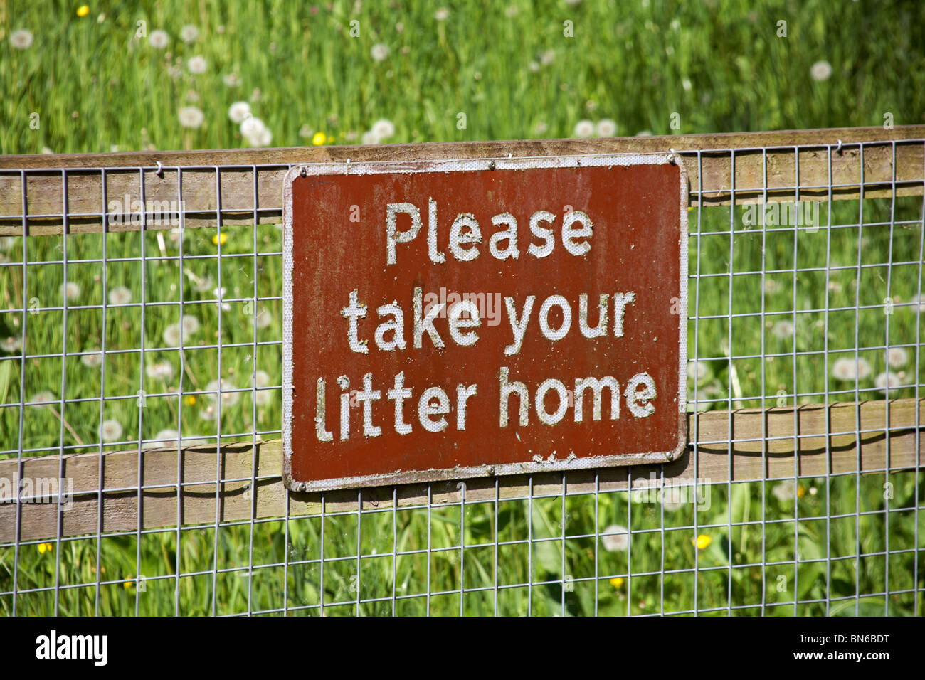 Please take your litter home notice on fence Stock Photo