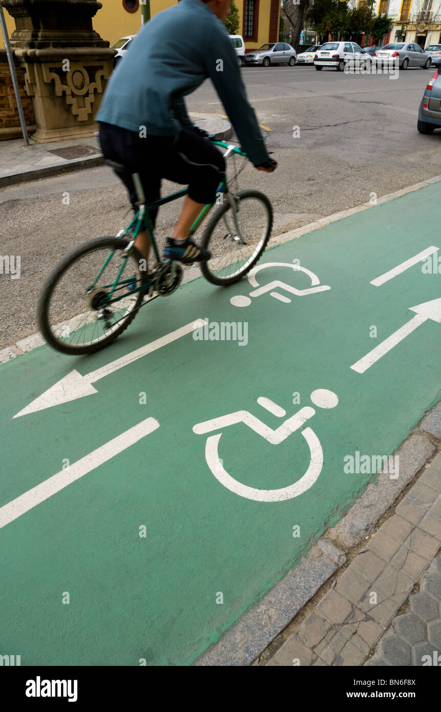 Cyclist cycles along a Spanish wheelchair / disabled person and bicycle