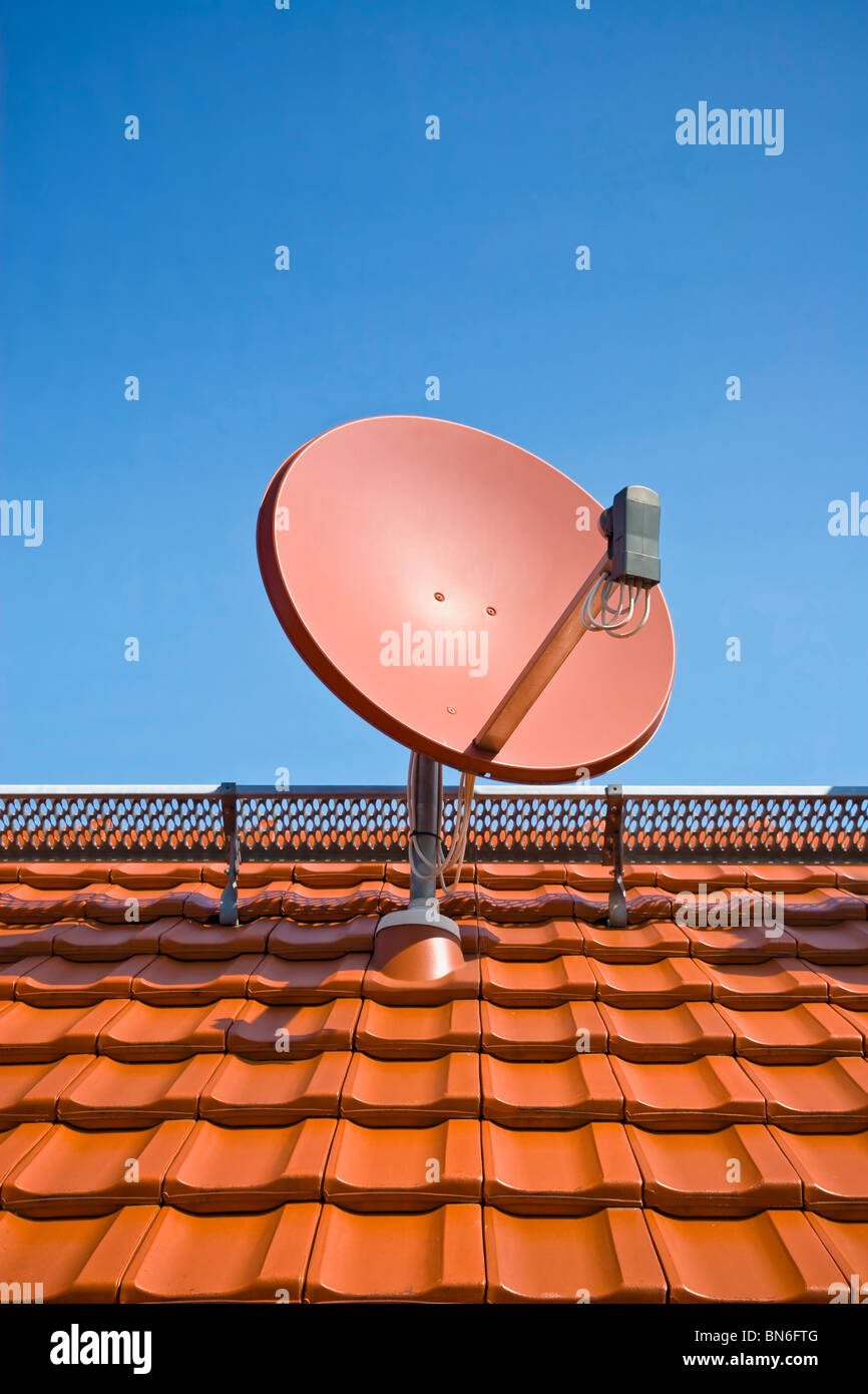 Satellite dish on roof with clear blue sky Stock Photo