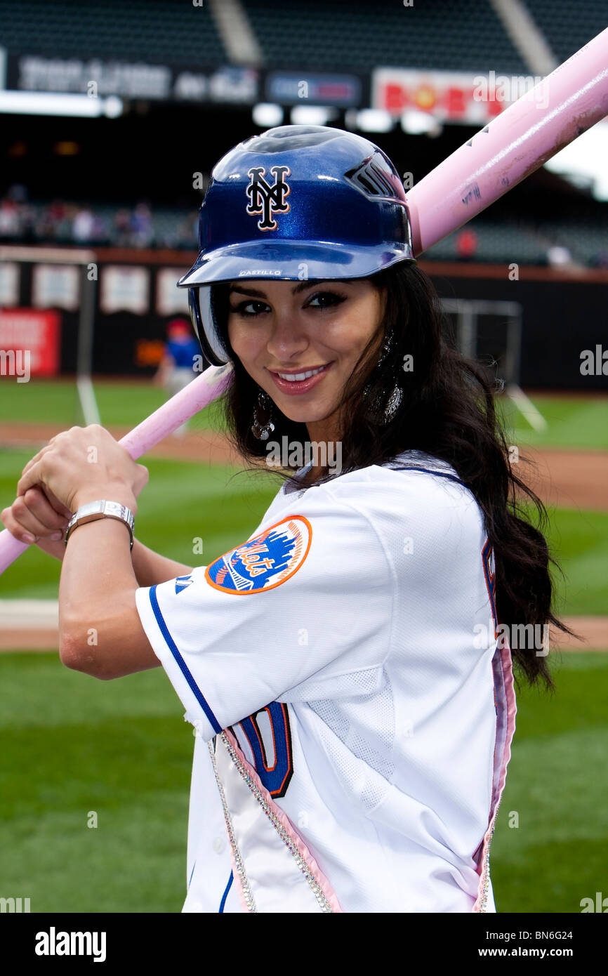 Miss USA, Rima Fakih, wearing jersey, holding pink bat and blue